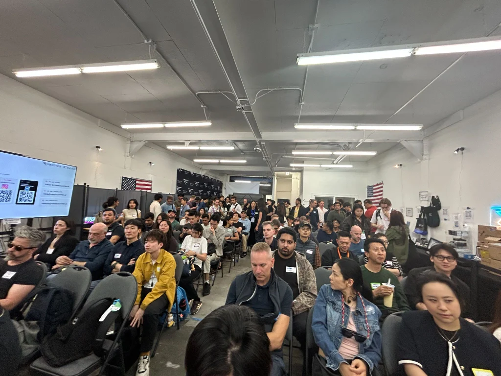 Around 200 attendees seated in the Robotics Center garage during the Physical AI Operators panel