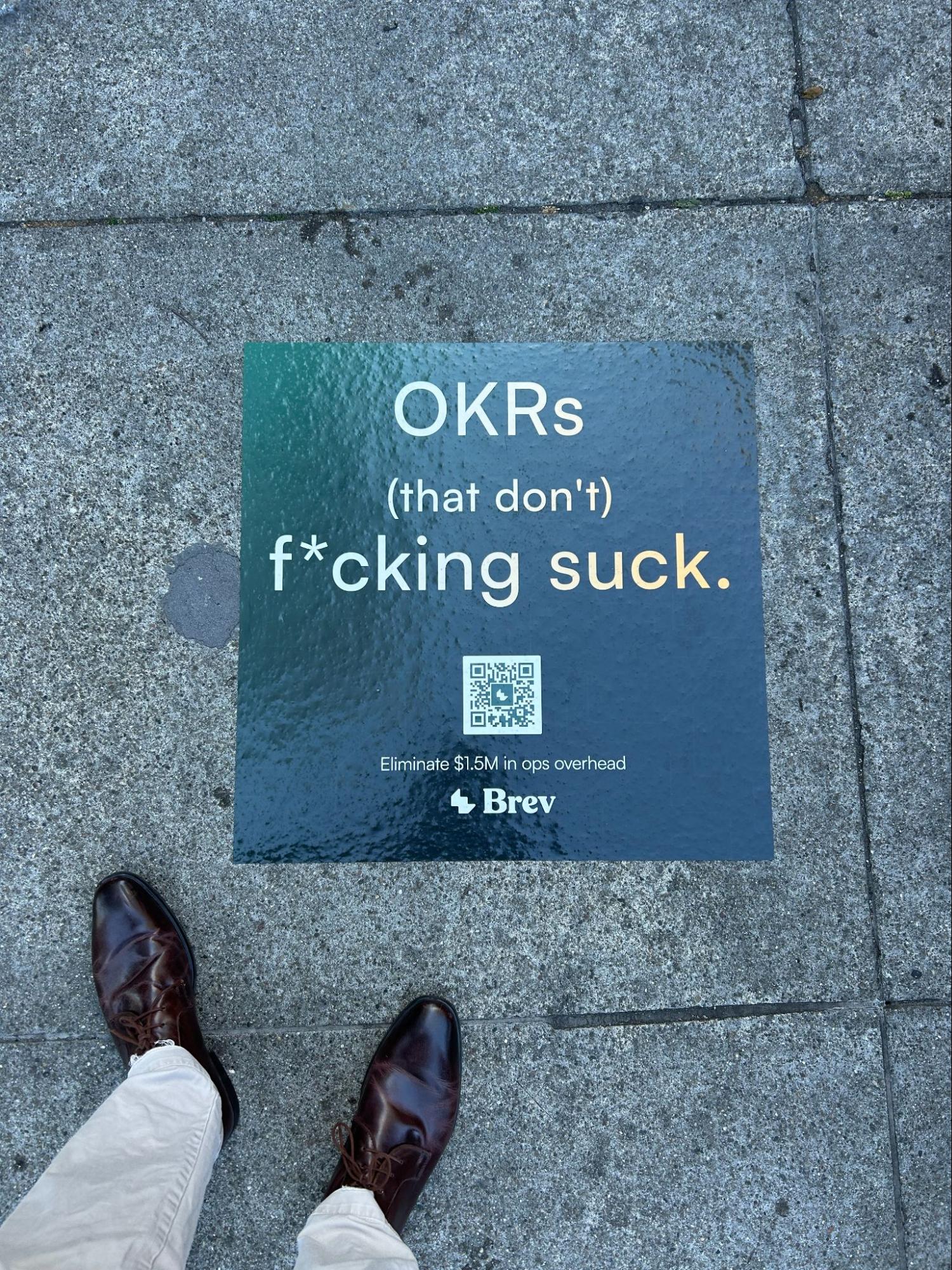 Even the pavement sells software: a sidewalk sticker from the startup Brev in San Francisco during Tech Week.